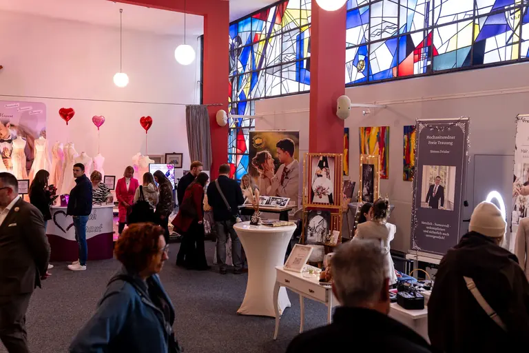Wedding Emotions Prüm 2026 – Weite Saalansicht mit roten Säulen und Buntglasfenstern